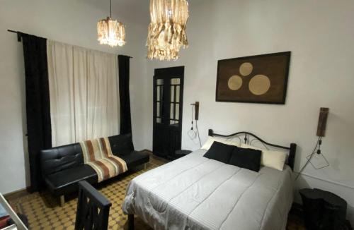 ein Schlafzimmer mit einem Bett und einem Stuhl in der Unterkunft En Remolinos in Cruz del Eje