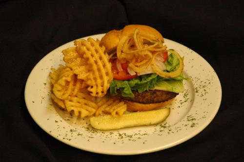 a plate with a sandwich and fries and a pickle at DoubleTree by Hilton Holland in Holland