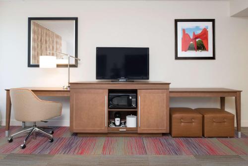 a room with a desk with a television and a desk at Hampton Inn Grand Rapids-South in Wyoming