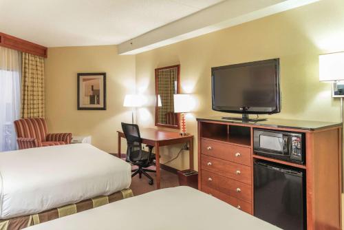 a hotel room with a bed and a flat screen tv at DoubleTree by Hilton Holland in Holland