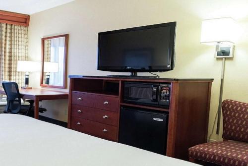 a hotel room with a bed and a television on a dresser at DoubleTree by Hilton Holland in Holland