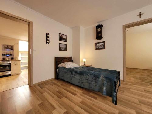 a bedroom with a bed and a cross on the wall at Noclegi Przy Niemczówce in Chęciny