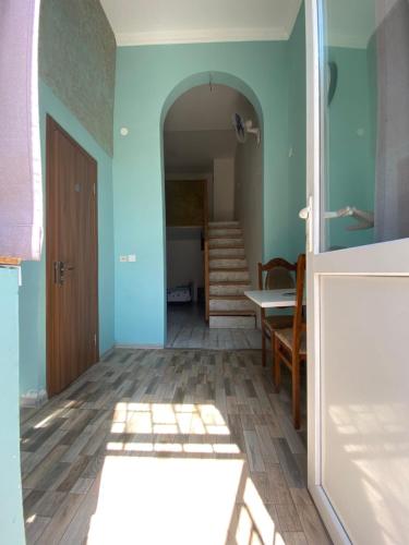 a room with a hallway with blue walls and a wooden floor at Eli’s home in Borjomi