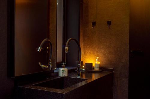 uma casa de banho com um lavatório e um espelho grande em Altar Ninho em Joanópolis