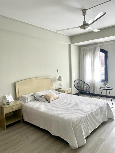 1 dormitorio blanco con 1 cama y ventilador de techo en Hotel Renacer Tarija, en Tarija