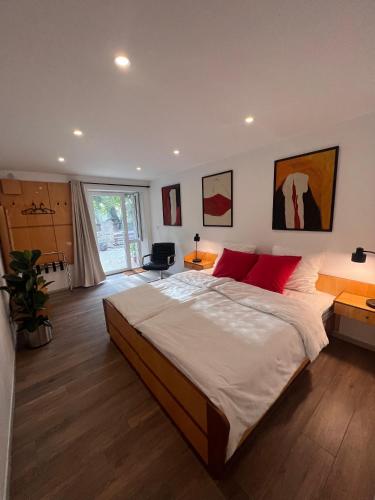 une chambre avec un grand lit avec des oreillers rouges dans l'établissement DOMAINE DES CAPUCINS, à Bussière-Saint-Georges