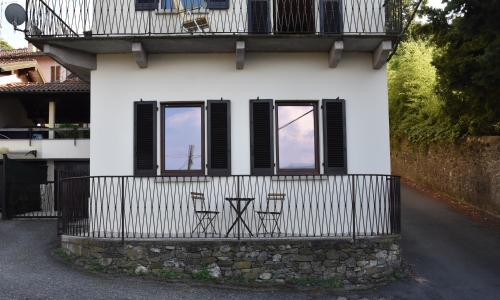 Biały dom z trzema krzesłami i płotem w obiekcie lognomoelafatinastresa w mieście Stresa