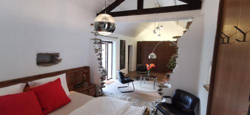 a bedroom with a bed and a chair in a room at DOMAINE DES CAPUCINS in Bussière-Saint-Georges