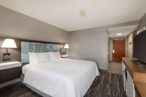 a hotel room with a bed and a flat screen tv at Hampton Inn Greenville-Simpsonville in Simpsonville