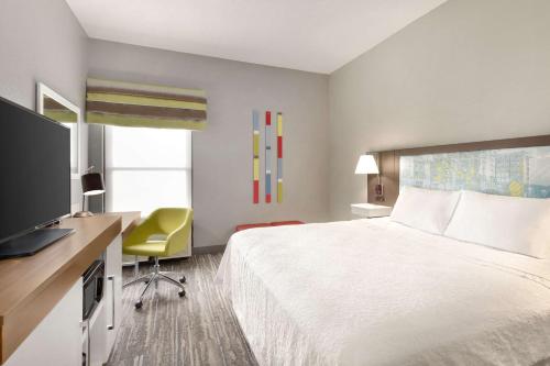 a hotel room with a bed and a flat screen tv at Hampton Inn Greenville-Simpsonville in Simpsonville