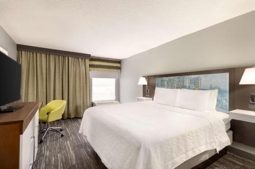 a hotel room with a bed and a yellow chair at Hampton Inn Greenville-Simpsonville in Simpsonville