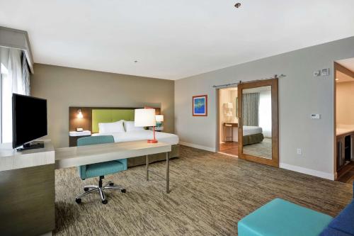 a hotel room with a bed and a desk with a computer at Hampton Inn & Suites Grants Pass in Grants Pass