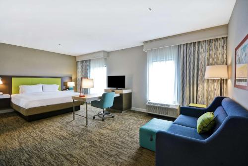 Hampton Inn & Suites Grants Pass في غرانتس باس: غرفه فندقيه بسرير واريكه