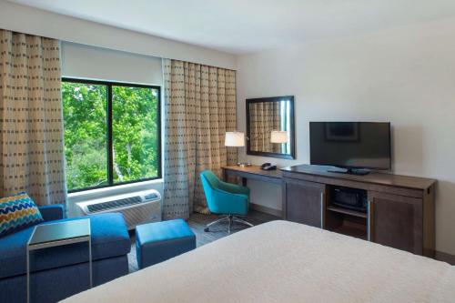 a hotel room with a bed and a desk and a television at Hampton Inn Gulf Shores in Gulf Shores