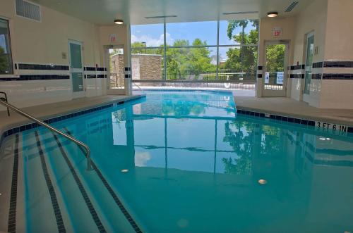 a large swimming pool with blue water in a building at Hilton Garden Inn Gainesville in Gainesville