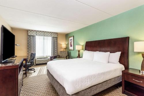 a hotel room with a bed and a flat screen tv at Hilton Garden Inn Gainesville in Gainesville