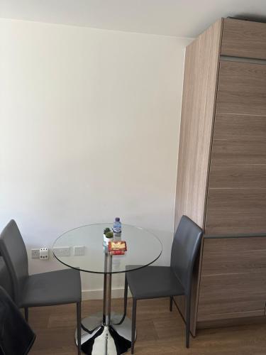 una mesa de cristal y 2 sillas en una habitación en Luxury one bedroom apartment, en Londres