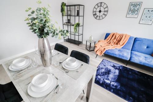 a living room with a table and a blue couch at Modern House with Gated Driveway and Free WiFi in Luton