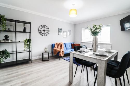 a living room with a table and chairs and a couch at Modern House with Gated Driveway and Free WiFi in Luton