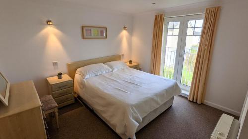 a bedroom with a large bed and a window at Atlantic Reach Cottages, Newquay 6 miles, 2 Bedrooms in Newquay