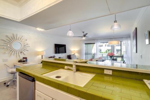 a kitchen with a sink and a living room at Retro-Inspired Palm Springs Condo with Pool View! in Palm Springs