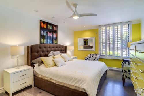 a bedroom with a large bed with yellow walls at Retro-Inspired Palm Springs Condo with Pool View! in Palm Springs