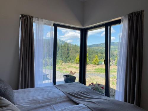 a bedroom with a bed in front of a large window at Grey apartments in Slavske