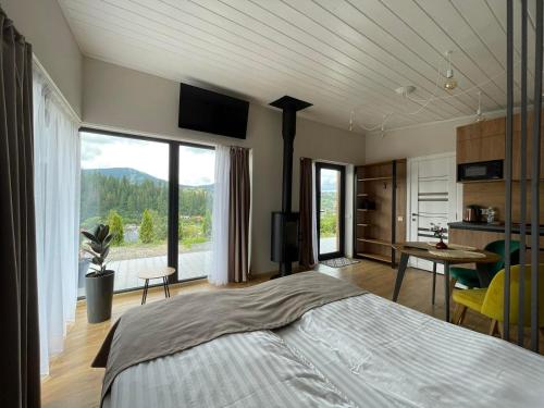 a bedroom with a large bed and a large window at Grey apartments in Slavske