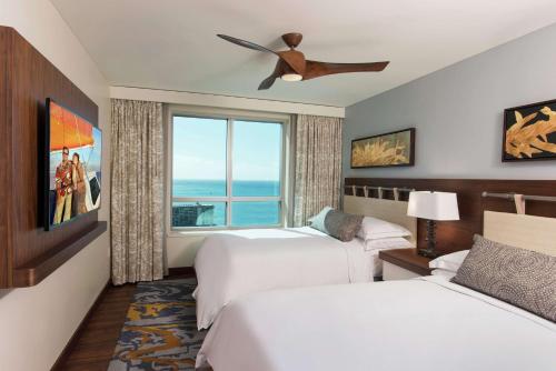 ホノルルにあるHilton Grand Vacation Club The Grand Islander Waikiki Honoluluのベッド2台と窓が備わるホテルルームです。