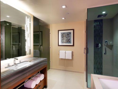 a bathroom with a sink and a shower at Hilton Grand Vacation Club The Grand Islander Waikiki Honolulu in Honolulu