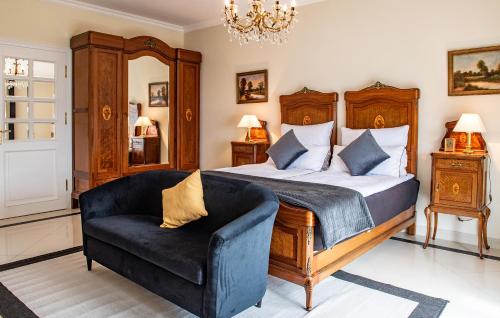 a bedroom with a bed and a chair and a chandelier at Prohipo Stables & LMC - Premium Rooms 