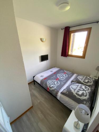 une petite chambre avec un lit et une fenêtre dans l'établissement Appart SFL 1650m, à Saint-François-Longchamp