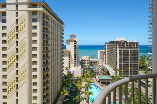 a view of the beach from the balcony of a building at Embassy Suites by Hilton Waikiki Beach Walk in Honolulu