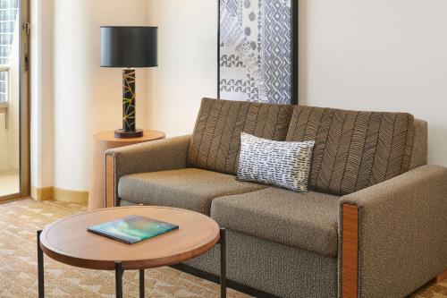 a living room with a couch and a table at Embassy Suites by Hilton Waikiki Beach Walk in Honolulu
