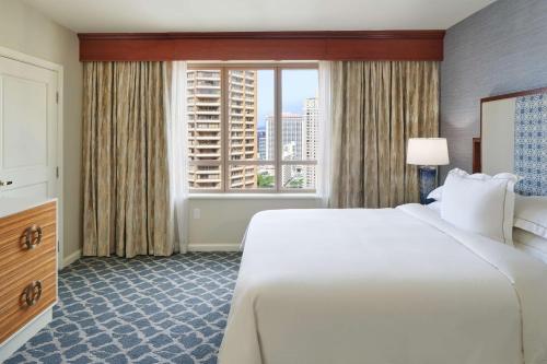 a hotel room with a large bed and a window at Hilton Grand Vacations Club Grand Waikikian Honolulu in Honolulu