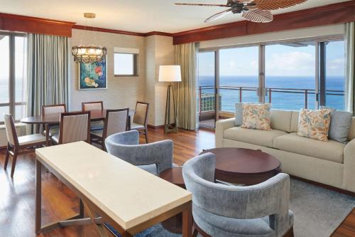 a living room with a couch and a table and chairs at Hilton Grand Vacations Club Grand Waikikian Honolulu in Honolulu