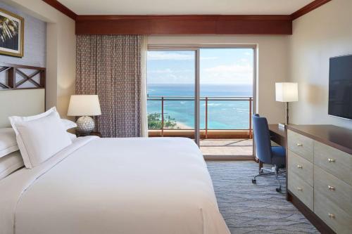 a hotel room with a bed and a large window at Hilton Grand Vacations Club Grand Waikikian Honolulu in Honolulu