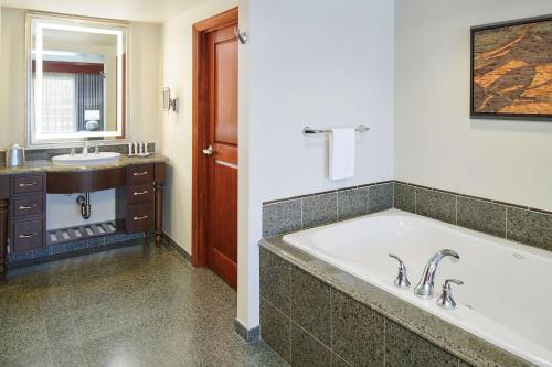 a bathroom with a large tub and a sink at Hilton Grand Vacations Club Grand Waikikian Honolulu in Honolulu