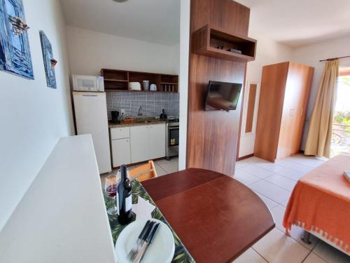 a kitchen with a table and a kitchen with a refrigerator at Apart Hotel Beira do Mar in Florianópolis