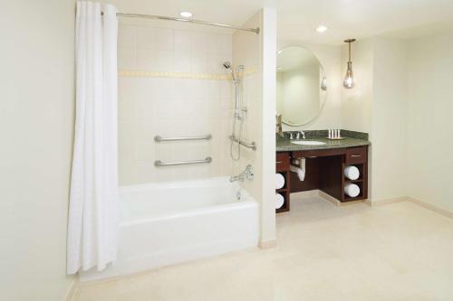 a bathroom with a shower and a tub and a sink at Hilton Grand Vacations Club Grand Waikikian Honolulu in Honolulu