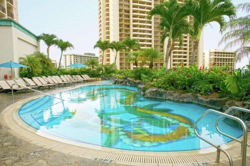 a large swimming pool in the middle of a resort at Hilton Grand Vacations Club at Hilton Hawaiian Village in Honolulu