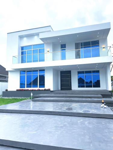 una casa blanca con muchas ventanas en Contemporary 4-Bedroom Villa with VR Room and Starlink Internet - Ifemide Estates, en Akure