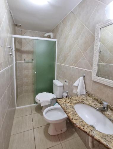 a bathroom with a toilet and a sink and a shower at Apart Hotel Beira do Mar in Florianópolis