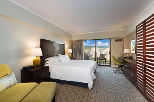 a hotel room with a bed and a balcony at Hilton Grand Vacations Club at Hilton Hawaiian Village in Honolulu