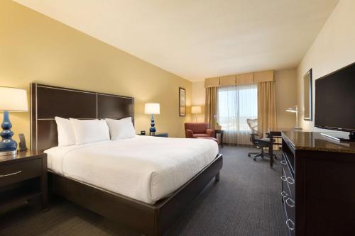 a hotel room with a bed and a desk at Hilton Garden Inn Houston NW America Plaza in Houston
