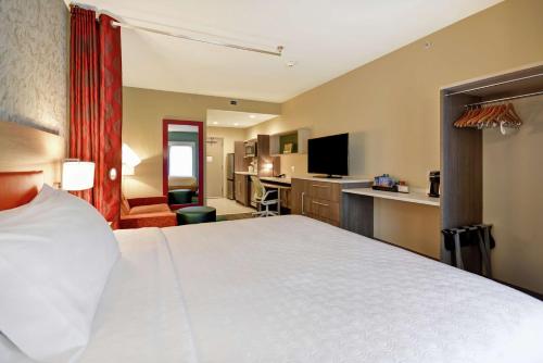 a hotel room with a large bed and a television at Home2 Suites At The Galleria in Houston