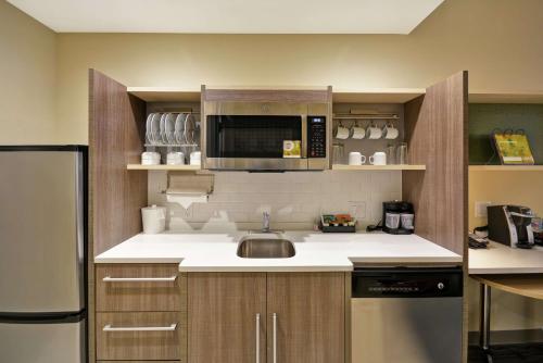 a kitchen with a sink and a microwave at Home2 Suites At The Galleria in Houston