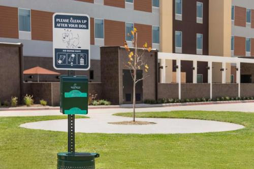 a street sign in the grass in front of a building at Home2 Suites by Hilton Houston Stafford - Sugar Land in Stafford