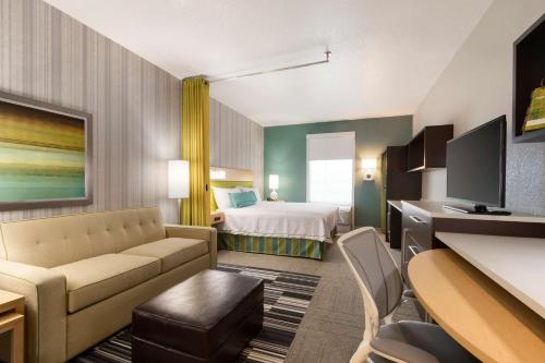 a hotel room with a couch and a bed at Home2 Suites by Hilton Houston Stafford - Sugar Land in Stafford