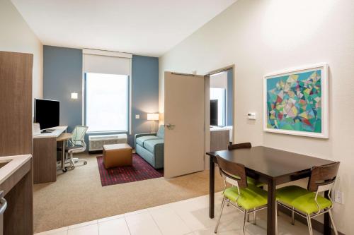 a living room with a table and chairs in a room at Home2 Suites by Hilton Houston Bush Intercontinental Airport Iah Beltway 8 in Houston